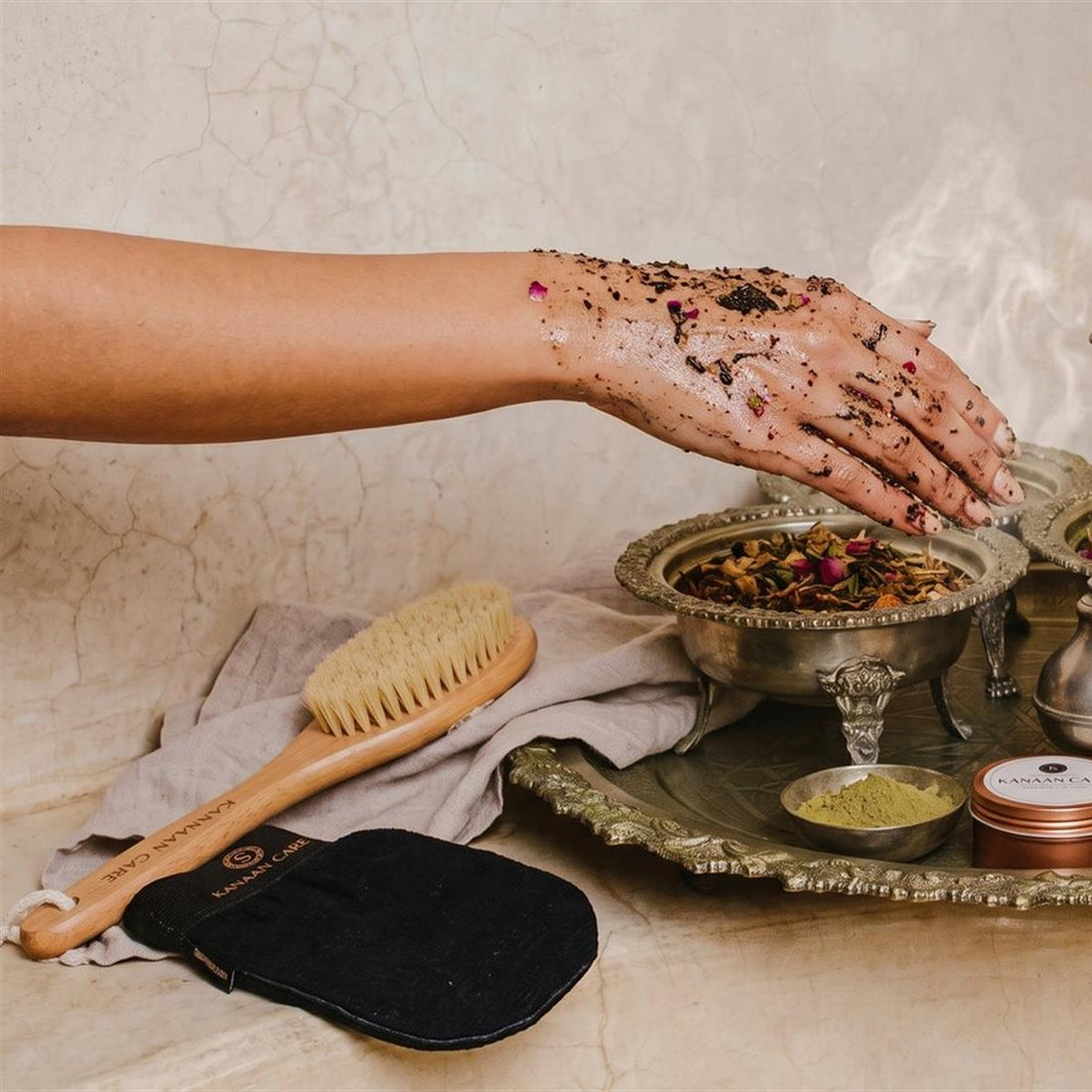 Kanaan Care daily body-care ritual with a botanical scrub and Moroccan bath brush